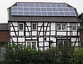 Old timber framed house with a photovoltaic array