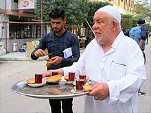 Tea being served in Karbala, Iraq Tea and Biscuits (30700190145).jpg