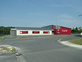 Fotografia colorida de edifícios e garagens pintadas em branco e vermelho.