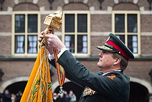 King Willem-Alexander attaching the lanyard of the Military Order of William to the colour of the Korps Commandotroepen in 2016. Uitreiking Militaire Willems-Orde KCT 2016-5.jpg