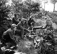 British Vickers gunners in action in the Netherlands during Operation Market Garden. All are wearing the Mk III Turtle helmet.