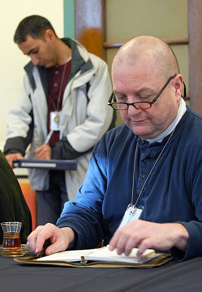 File:Wade Brower reviews his notes while an evaluator critiques his performance, 2011.jpg