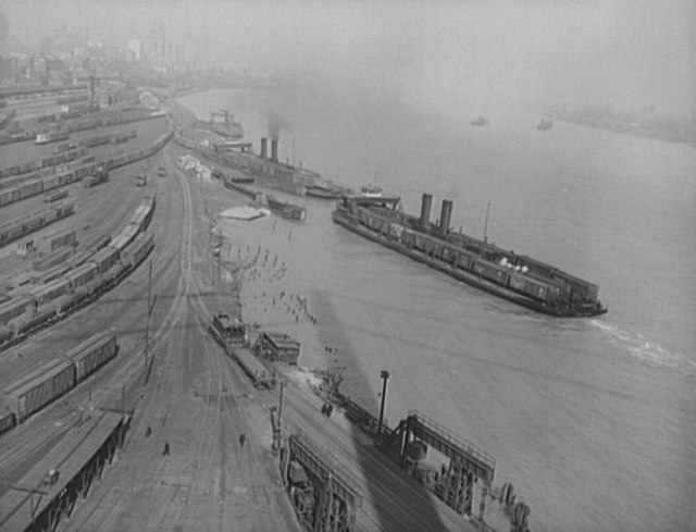 Aerial view of a classification yard and two train ferries, 1943