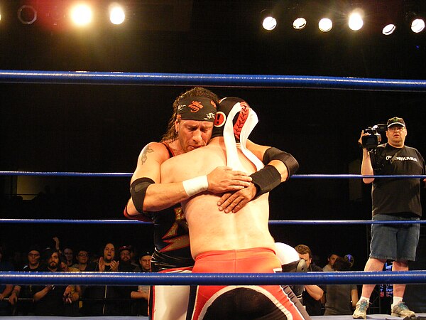 1–2–3 Kid (left) embracing El Generico after their match at King of Trios on April 17, 2011