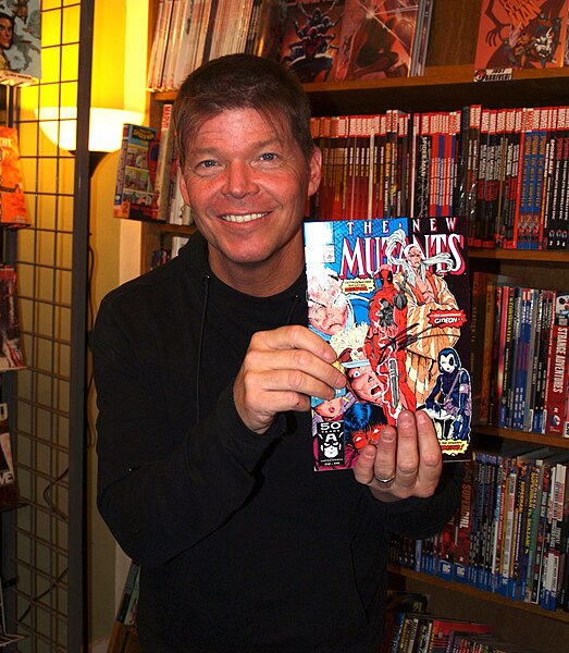 The character's co-creator, Rob Liefeld, holding up a copy of New Mutants #98, in which the character first appeared, during an appearance at JHU Comi