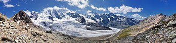 Panorâmica da cordilheira Bernina e da geleira Morteratsch vistas da montanha Diavolezza, no cantão dos Grisões, Suíça. Ela é uma geleira alpina e como quase todas as geleiras alpinas, ela também é afetada por um encolhimento como resultado do aquecimento global; encurtou cerca de 2,5 quilômetros entre 1900 e 2017. Hoje ainda restam cerca de 6,2 quilômetros de extensão, tornando-se a terceira maior geleira dos Alpes Orientais depois de Pasterze e Gepatschferner nos Alpes austríacos. (definição 14 897 × 3 628)