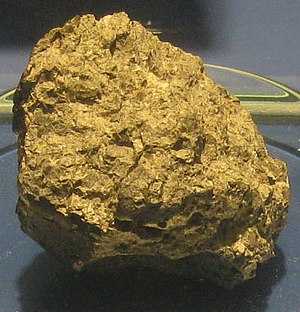 A rough-hewn rock with a yellowish sheen.