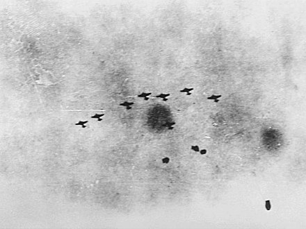 A formation of Japanese bombers taking anti-aircraft fire, seen from the Australian cruiser, HMAS Hobart.