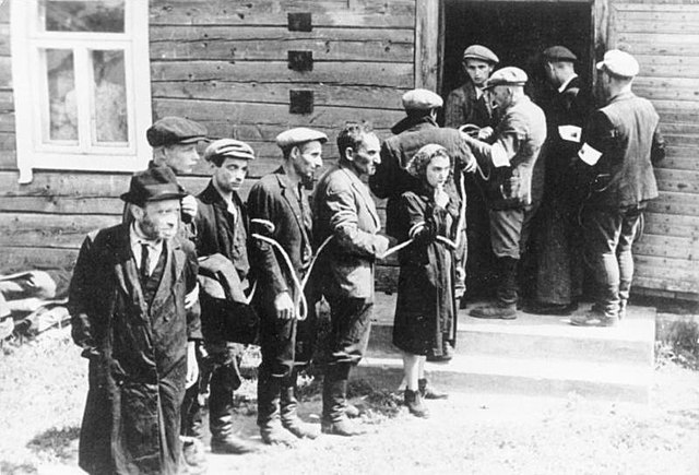 Lithuanian collaborators (with white armbands) arresting the Jews in July 1941