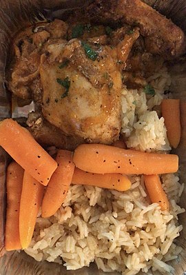 A meal consisting of chicken served with carrots and rice.