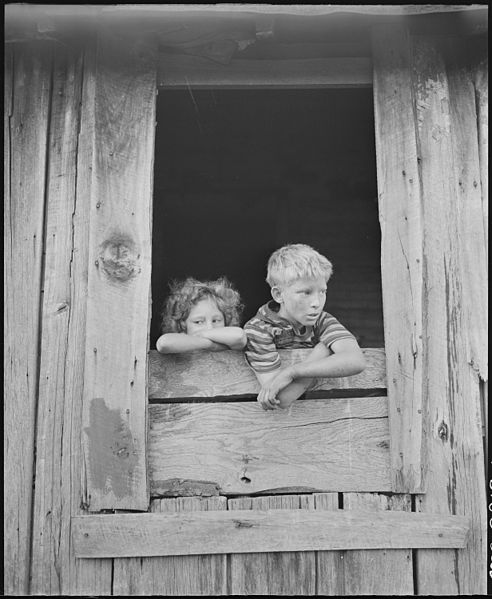 File:Children of miners look out the kitchen window of the Monroe Jones house. The windows have no panes, the door frames... - NARA - 541187.jpg