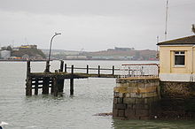 The original pier (as it appeared in 2007) where passengers boarded tenders to the Titanic at its anchorage near the mouth of the harbour. The corner of the office building of the White Star Line can be seen on the right. The building today houses a Titanic museum.