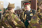 Kroonprins Willem-Alexander reikt na het volbrengen van de commando-opleiding de groene baret uit aan een nieuwe commando die een mutsdas draagt (dec 2009)