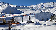 Área de esqui coberta de neve com teleféricos.