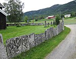 Kyrkogårdsmuren med stenhällarna.