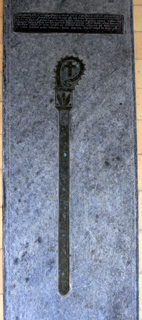 Monumental brass to George Cary (1543-1601), floor of chancel, All Saints Church, Clovelly. The bishop's crozier is a reproduction inserted in the 1860s into an empty matrix. GeorgeCary Died1601 ClovellyChurch Devon.PNG