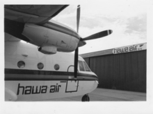 The Hawa Air C-212-200 Aviocar before the purposely built hangar of the same company. Hawa.Casa212AvioCar.HangarProp.BW.png