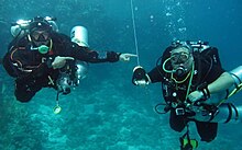 Scuba divers at a decompression stop using a reel and decompression buoy to help keep constant depth and alert the surface as to their location and status. Jeffrey phillips freeman deco stop egypt.jpg