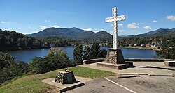 A Christian cross stands above the community.