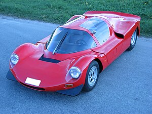 Red, low racing car with doors starting from the roof.