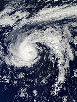 Satellite image of Hurricane Nadine. Toward the center, a small, faint eye is visible. A long spiral band also extends to the east.