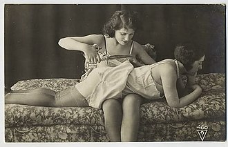 A dominatrix cuts the clothes of a submissive female to strip her. Image of Studio Biederer, 1920s, France. Ostra 460.jpg