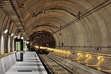 Voie sans ballast du type "Low Vibration Track" avec des rails fixés sur des traverses/traverses en béton qui sont fixées dans une dalle en béton dans la station multifonction Sedrun du tunnel de base du Saint-Gothard.