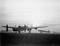 Lancasters on the tarmacadam await launch for raid at dusk