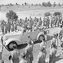 HM King George VI rides with General Montgomery in a staff car between lines of cheering troops during his first visit to Tripoli, 21 June 1943. The British Army in North Africa 1943 E25431.jpg