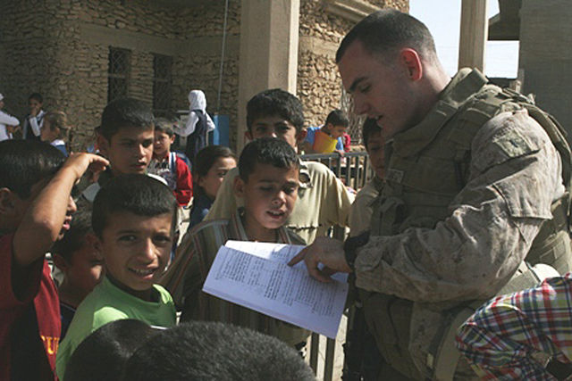 1st Lt. Mike Gallagher reading a book to children at Al Moaine Elementary School in Rawah, Iraq, 13 October 2008