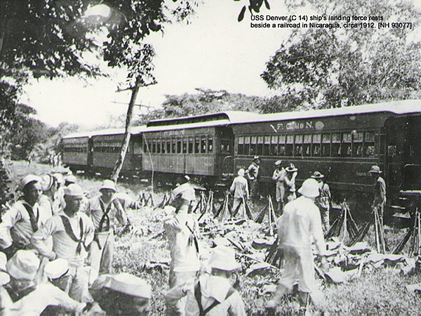 The USS Denver ship's landing force under Lt. A. Reed rests beside the Corinto, Nicaragua railroad line, 1912.