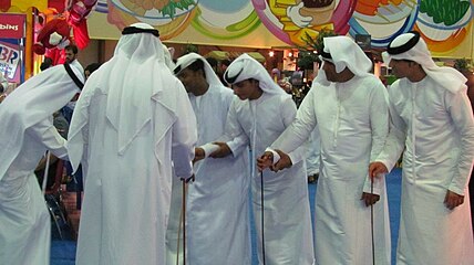 رجال من الإمارات يرقصون اليولة وهي فلكلور شعبي إماراتي