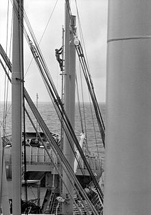 An able-bodied seaman climbs a kingpost to perform maintenance aboard a general cargo ship or freighter. Aloft2.jpg