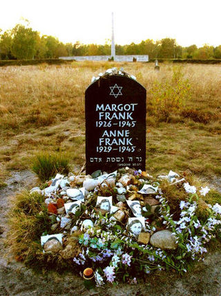 位於貝爾根-貝爾森集中營集中營舊址的紀念碑，周邊滿佈人們悼念的鮮花和圖片。