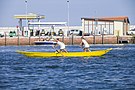 due donne che remano una barca gialla in una giornata di sole