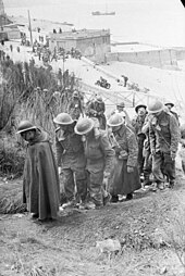 Captured British and French soldiers help one another on the staircase up to the cliff at Veules-les-Roses, June 1940 British prisoners at Dunkerque, France.jpg