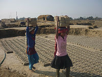 Filles népalaises transportant des briques.