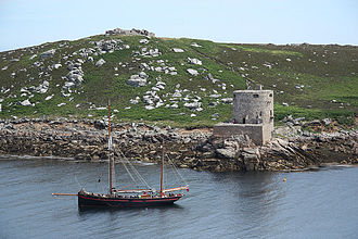 The castle seen from the sea, overlooked by the ruined King Charles's Castle Cromwell Castle and King Charles's Castle.jpg