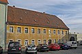 Semi-open residential building, two outbuildings and an enclosure wall with an archway