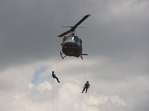 Brasilianska fallskärmsjägare genomför rappelling från en helikopter.