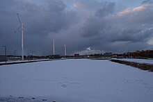 Lake frozen over in Father Collins Park with distinctive wind turbines in the background