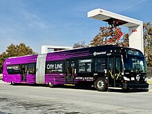 A 5-door XE60 battery electric bus with City Line livery operated by Spokane Transit charging via SAE J3105 overhead charging station. Full Spokane City Line bus charging at SCC transit center October 2023.jpg