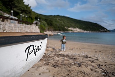 Gabriel at Prapratno Beach next to a fishing boat, Croatia