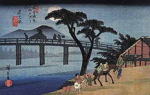 A rather dark printing of the view sometimes dubbed Man on Horseback Crossing a Bridge. From the series The Sixty-nine Stations of the Kiso Kaidō, this is View 28 and Station 27 at Nagakubo-shuku, depicting the Wada Bridge across the Yoda River.[20]