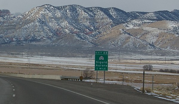 Road sign along Interstate 70 in Utah signaling traffic destined for the towns of Sigurd and Aurora to exit the freeway. The road at this exit is offi