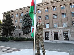 ハンケンディ（アルメニア語名・ステパナケルト）の「アルツァフ共和国大統領府」前でアゼルバイジャン国旗を掲揚する（2023年10月15日）