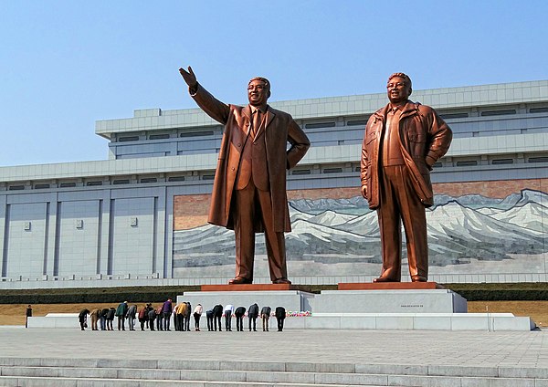 The Mansudae Grand Monument in Pyongyang in 2014 depicting Kim Il Sung (left) and Kim Jong Il (right), with visitors paying homage to the statues.