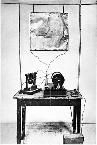 Marconi's first transmitter incorporating a monopole antenna. It consisted of an elevated copper sheet (top) connected to a Righi spark gap (left) powered by an induction coil (center) with a telegraph key (right) to switch it on and off to spell out text messages in Morse code. Marconi's first radio transmitter.jpg