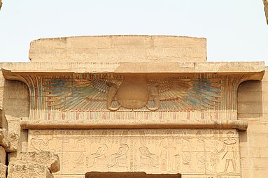 Sole alato su una cornice dal complesso del tempio di Medinet Habu. Il sole alato rappresenta una forma del dio falco Horus, figlio di Iside, trionfante sui suoi nemici. L'immagine era anche un comune dispositivo di protezione sugli ingressi del tempio