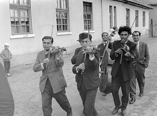 Men playing stringed instruments while walking.